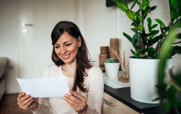 Beautiful casual happy woman looking at received letterQuick Reliable Printing (QRP)