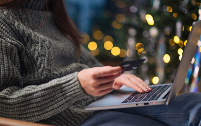 Christmas online shopping sales and discounts promotions during winter holidays online shopping at home Female hands on the laptop with credit card and blurred bokeh lightsQuick Reliable Printing (QRP)