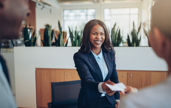 Laughing African American concierge talking with guests during check inQuick Reliable Printing (QRP)