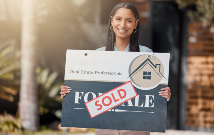 Shot of a real estate agent standing next to a sold sign outsideQuick Reliable Printing (QRP)