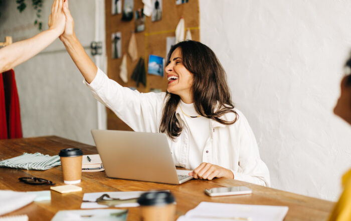 Successful fashion designers celebrating their teamwork and accomplishment in an officeQuick Reliable Printing (QRP)