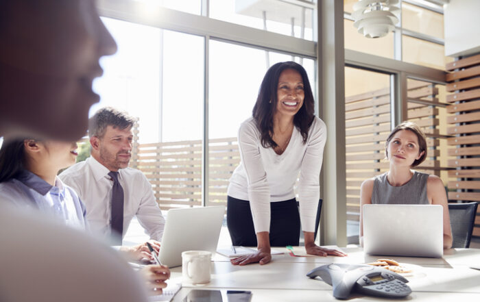 Smiling female manager listening to colleagues at a meetingQuick Reliable Printing (QRP)