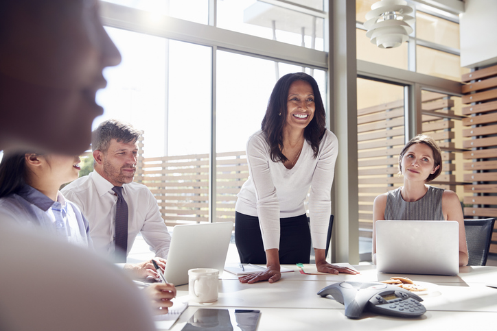 Smiling female manager listening to colleagues at a meetingQuick Reliable Printing (QRP)