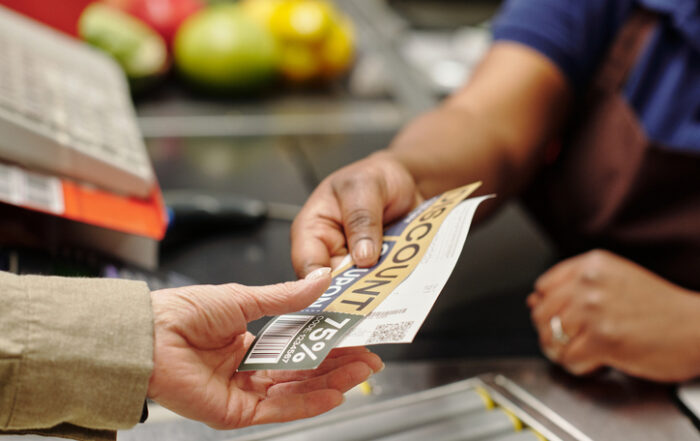 Hand of young female cashier passing discount coupon and receit to customerQuick Reliable Printing (QRP)