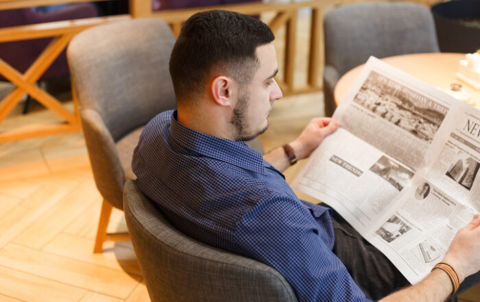 Man reading a newspaper in cafeQuick Reliable Printing (QRP)