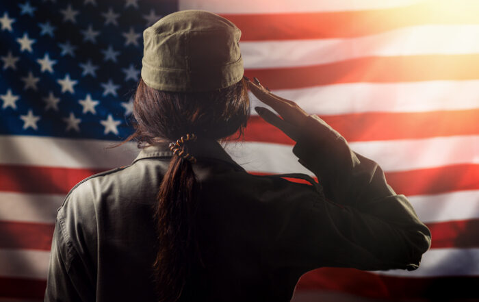 Veterans Day Memorial Day Independence Day A female soldier saluting against the background of the American flag Back view Light Concept of national American holidays and patriotismQuick Reliable Printing (QRP)