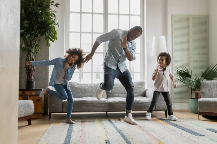 Happy african american father showing funny dancing moves to kids | Quick Reliable Printing (QRP) Quick Reliable Printing (QRP)